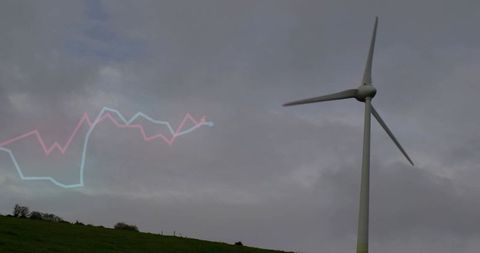 Wind turbine turning overcast sky with cyan pink line graph overlay for energy analytics