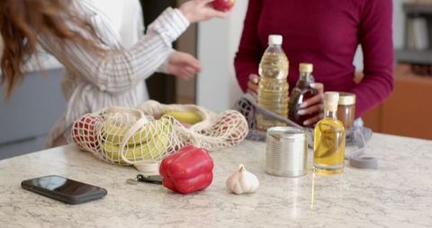 Women Organizing Healthy Food on Modern Kitchen Counter
