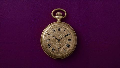 Elegant british empire antique gold pocket watch on purple velvet surface
