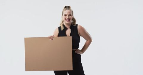 Confident Plus Size Woman Holding Blank Sign in Black Activewear
