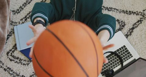 Teen playing with basketball while relaxing online