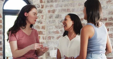 Expectant Mother Sharing Pregnancy News with Friends in Bright Kitchen