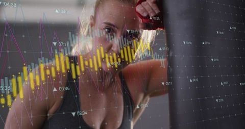 Female boxer training with financial data overlay on punching bag, fitness and analytics concept