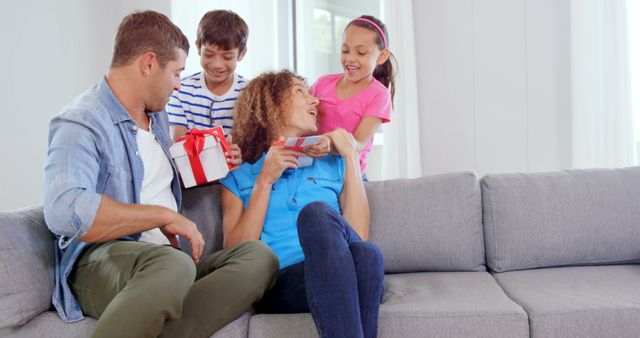 Happy Family Giving Gifts at Home on a Cozy Couch - Download Free Stock Images Pikwizard.com