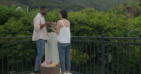 Couple Preparing Patio for Outdoor Celebration with Cushions