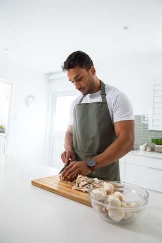 Home Chef Chopping Mushrooms in Bright Kitchen