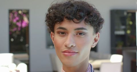Stylish Young Man with Curly Hair in Elegant Living Room
