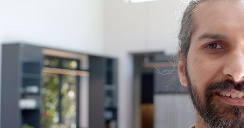 Confident Man with Long Hair Relaxing in Contemporary Kitchen