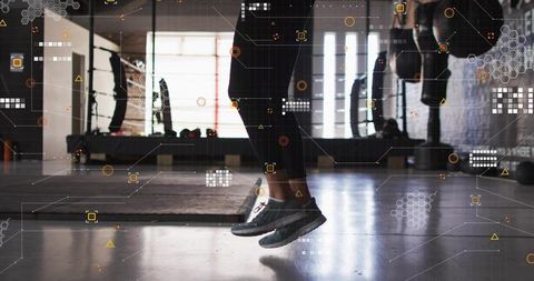 Jumping workout in fitness studio with futuristic data overlay, feet suspended above mat