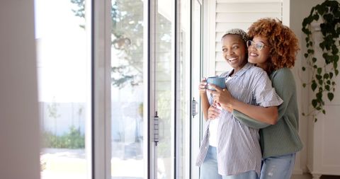 Happy Couple Embracing by Window, Showing Love at Home - Download Free Stock Images Pikwizard.com