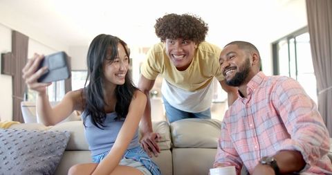 Diverse Friends Smiling for Selfie While Relaxing Indoors