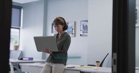 Professional in Modern Office Using Laptop