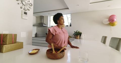 Woman Preparing Kitchen for Party with Gifts and Decorations