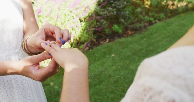 Diverse female couple wearing ring on sunny day in garden. wedding day and celebration concept.