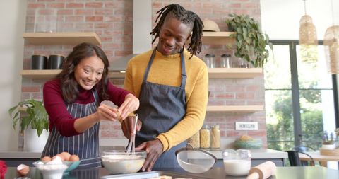 Joyful Diverse Couple Baking Together in Bright Kitchen