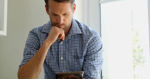 Caucasian Businessman Focused on Tablet by Sunny Window - Download Free Stock Images Pikwizard.com