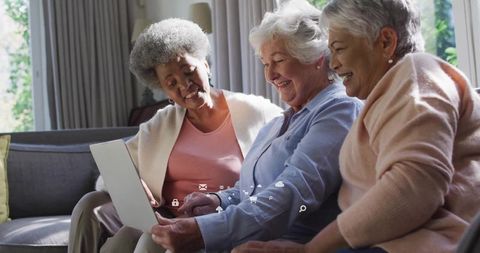 Senior Women Enjoying Technology Together on Sofa