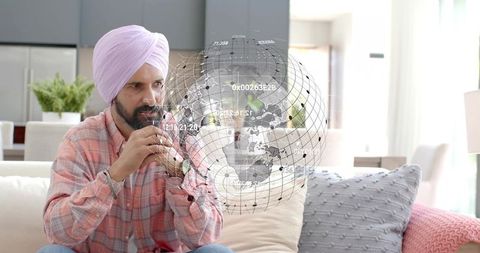 Sipping tea in pink turban and plaid shirt with holographic globe overlay