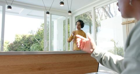 Playing Pool with Friends in Sunlit Modern Lounge with Sliding Glass Doors and Hardwood Table