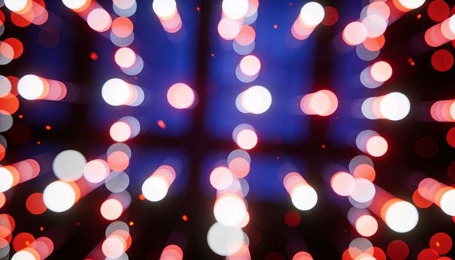 Glowing bokeh orbs streaming over deep blue grid with red-white light trails and orange sparks