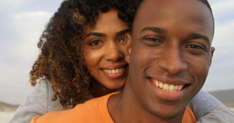 Smiling couple embracing on beach background