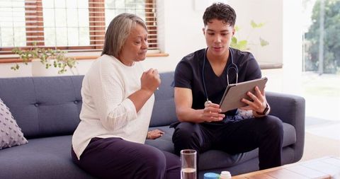 Physiotherapist Using Tablet for Treatment Plan with Senior Woman