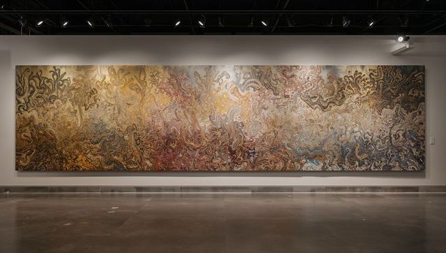 Displaying panoramic marbled abstract mural on museum wall under track lighting