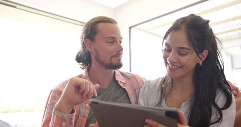 Young Couple Using Tablet Relaxing on Couch at Home