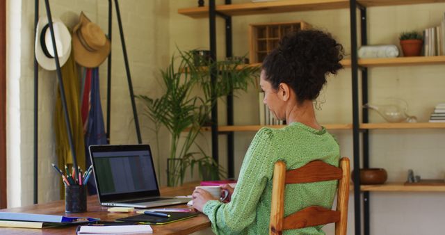Biracial woman stretching her arms while working from home - Download Free Stock Photos Pikwizard.com