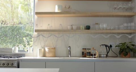 Bright Minimalist Kitchen Countertop with Stainless-Steel Sink Chrome Faucet and French Press