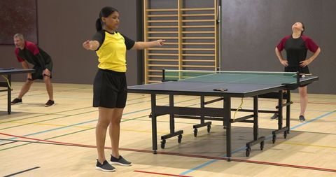 Diverse Athletes Engaged in Table Tennis Training Session