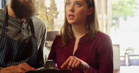 Colleagues discussing details in organic market with clipboard