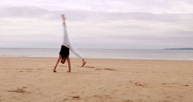 Person Performing Cartwheel on Serene Beach - Download Free Stock Images Pikwizard.com