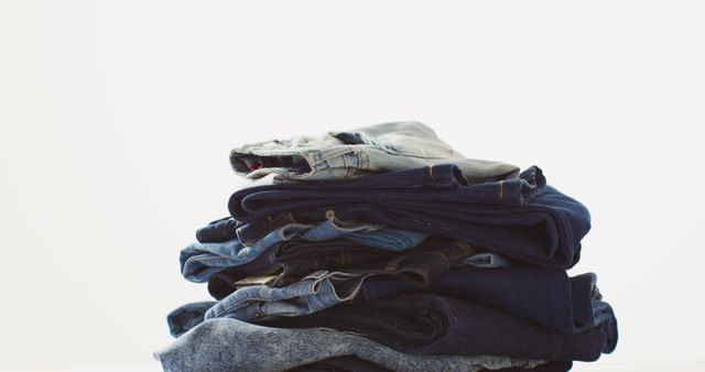 Perfect for blog articles, advertisements and social media posts relating to fashion, wardrobe organization or retail promotion. Image showcases neatly folded jeans in different shades of blue, providing a clean and simple aesthetic.