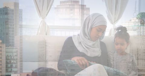 Mother and Daughter in Hijab Bonding Indoors with Cityscape Overlay