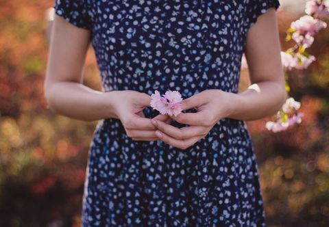 Woman Holding Blossoms in Nature, Connection to Spring