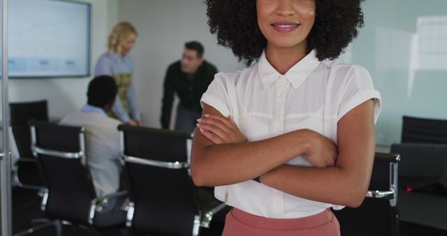 Confident Businesswoman in Modern Office with Team Meeting in Background - Download Free Stock Images Pikwizard.com