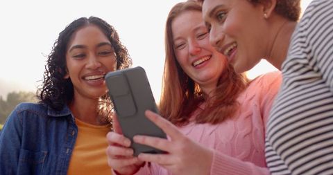 Group of Diverse Female Friends Looking at Smartphone in Park