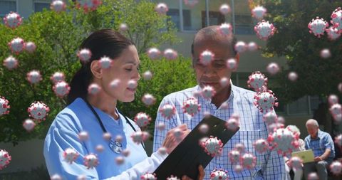 Healthcare Worker Consults Patient Amidst Floating Virus Graphics