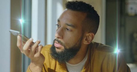 Bearded creative professional using smartphone voice command