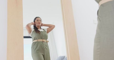 Woman Fashionably Posing at Mirror in Modern Bright Bedroom