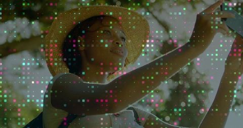 Woman in Straw Hat Taking Selfie Outdoors with Smartphone