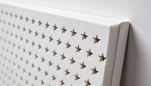 White acoustic panel with star-shaped perforations, beveled edge and textured depth