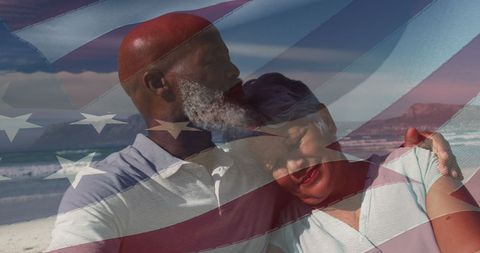 Senior Couple Embracing on Beach Underlaid with USA Flag
