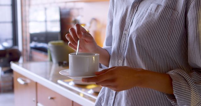 Woman Stirring Coffee in Modern Kitchen for a Relaxing Morning Routine - Download Free Stock Images Pikwizard.com