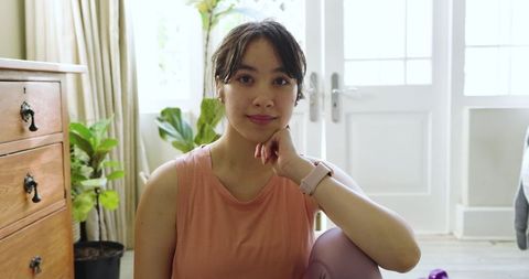 Young Asian Woman Relaxing Post-Workout in Modern Living Space