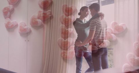 Intimate embrace of diverse gay couple with heart overlays