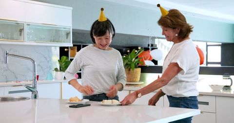 Multiracial friends enjoying post-party cleanup in kitchen