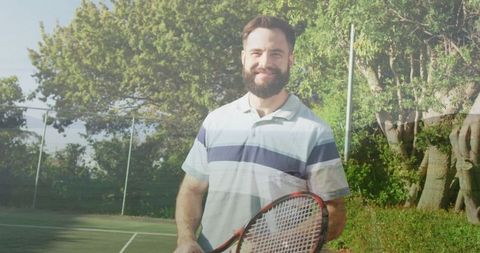 Man holding tennis racket standing on outdoor court