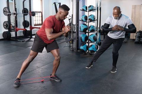 Trainer coaching athlete performing lateral band walk for hip stability and glute strength